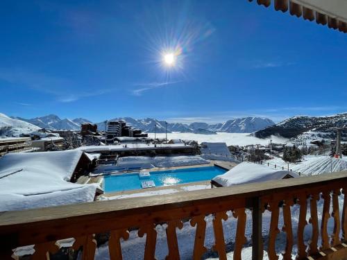 a view of a snowy mountain from the balcony of a resort at Superbe Studio avec vue exceptionnelle in L'Alpe-d'Huez
