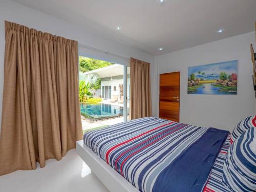sypialnia z łóżkiem i oknem z basenem w obiekcie VILLA MÉLÉTÉ - Family Home 3 bedrooms Koh Samui w mieście Lamai