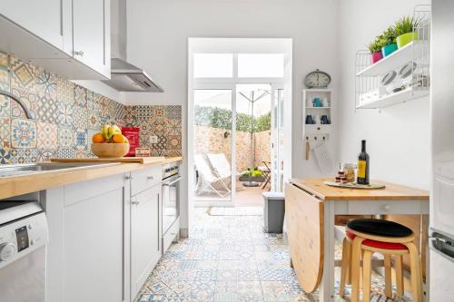 a kitchen with white cabinets and a tile floor at I Love Lisboa Apartment NEW AC in Lisbon