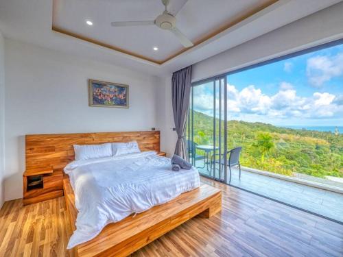 a bedroom with a bed and a large window at Reef View Villa in Lamai