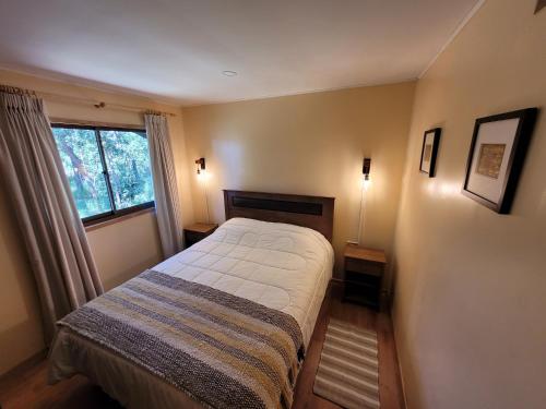 a small bedroom with a bed and a window at Cabañas Dahue in Valdivia