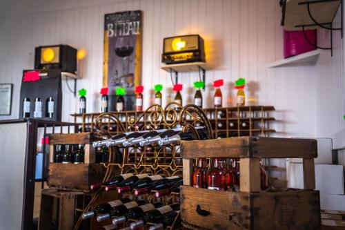 um monte de garrafas de vinho num quarto em Le Beunèze em LʼÉguille