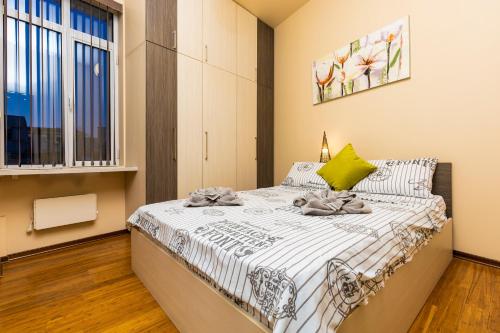 a small bedroom with a bed with a green pillow at 1BD Apartment with a Cute Balcony in Kapana by Flat Mаnager in Plovdiv