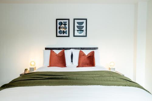 a bedroom with a large bed with red pillows at Modern Luxe 1 & 2 Bed Apts near Granby Plaza by Sojo Stay in Leicester