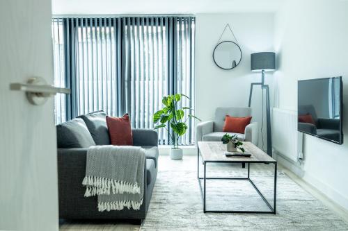 a living room with a couch and a table at Modern Luxe 1 & 2 Bed Apts near Granby Plaza by Sojo Stay in Leicester
