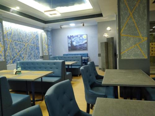 a dining room with blue chairs and tables and a window at Zip By Spree Hotels Surabi International Vellore in Vellore