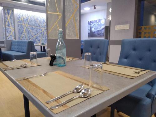 a table with a bottle and utensils on it at Zip By Spree Hotels Surabi International Vellore in Vellore