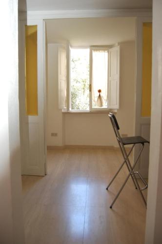 an empty room with a chair and a window at Arena Alfieri B&B in Livorno