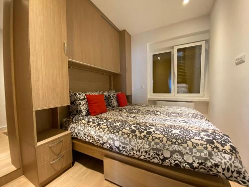 a small bedroom with a bed and a window at Linden Trsat with balcony in Rijeka