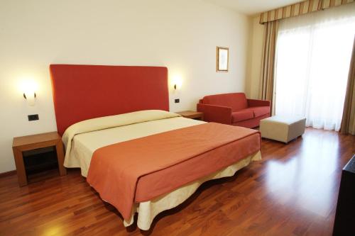 a hotel room with a bed and a chair at Hotel Cristallo di La Rosetta Srl in Assisi