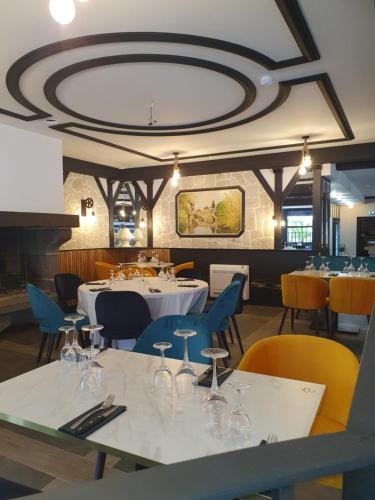 um restaurante com mesas e cadeiras com copos de vinho em Le Renaissance em Aurillac