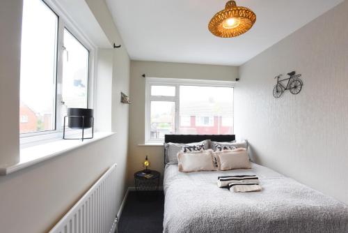 Un dormitorio con una cama con almohadas. en Westgate House - 5 bedroom newly renovated house with hot tub & private parking en Canterbury