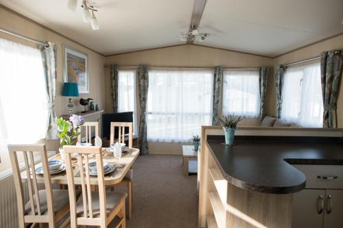 a kitchen and dining room with a table and chairs at Rockley Park Private Holiday Homes in Poole