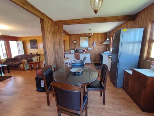 a kitchen and living room with a table and a refrigerator at Amplia y acogedora Casa, a 10 min de playa en auto in Los Molles