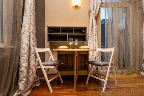 una mesa con 2 sillas y una copa de vino en 1BD Apartment with a Cute Balcony in Kapana, en Plovdiv