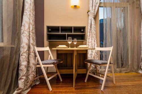 a table with two chairs and a wine glass at 1BD Apartment with a Cute Balcony in Kapana by Flat Mаnager in Plovdiv