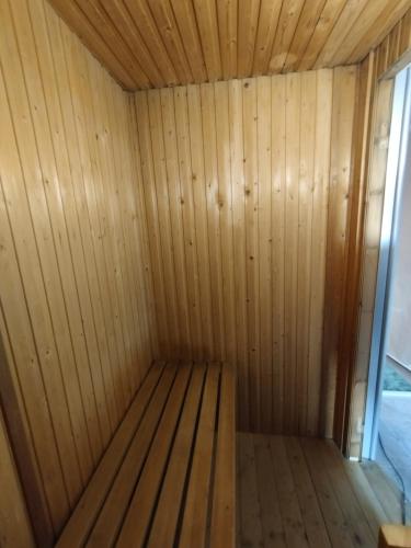 a wooden sauna with a bench in a room at City Inn Szigetvar in Szigetvár