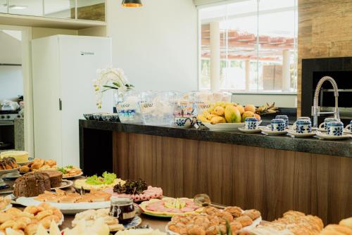 モンテシアンにあるPousada Saint Dinizのテーブルの上にさまざまな種類の食べ物が並んだビュッフェ