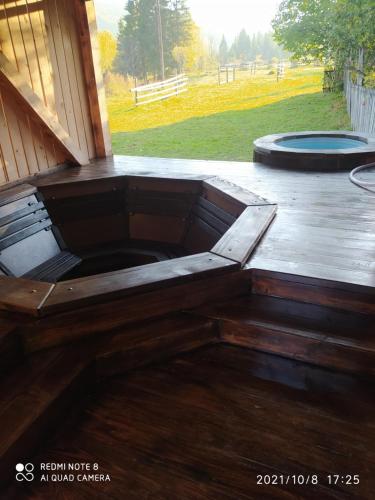 a wooden bench on a deck with a trampoline at Під Явором in Vorokhta