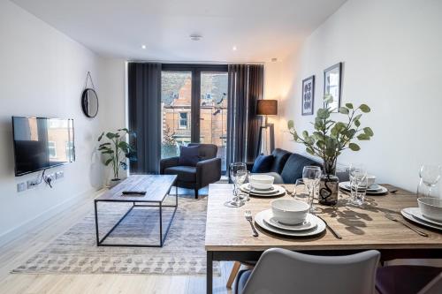 a living room with a table and a living room with a couch at Modern Luxe 1 & 2 Bed Apts near Granby Plaza by Sojo Stay in Leicester