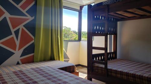 a bedroom with two bunk beds and a window at Mi Casa Tica Backpackers in Monteverde Costa Rica