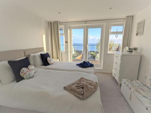 a bedroom with two beds with a view of the ocean at Jan Dee Cottage in Ventnor
