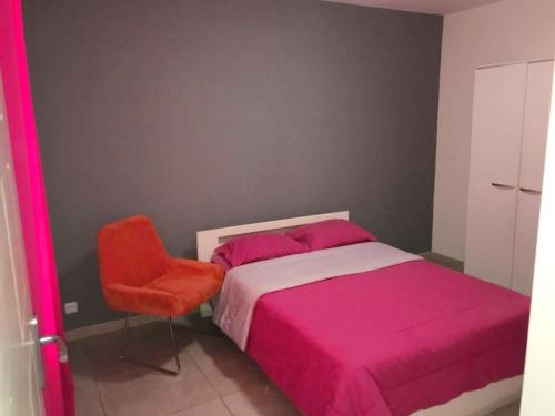 a bedroom with a pink bed and a chair at Maison charmante à Saint-Louis + Jacuzzi in Saint-Louis