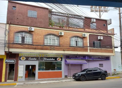 a black car parked in front of a building at Pousada Santa Terezinha in Aparecida