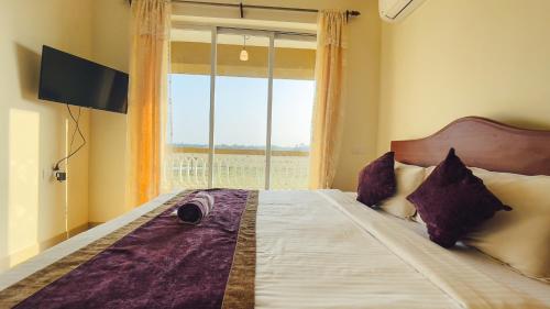 a bedroom with a large bed with a window at Calvin's Retreat in Varca