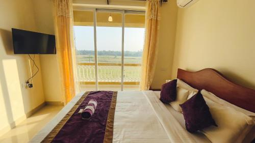 a bedroom with a bed with a large window at Calvin's Retreat in Varca