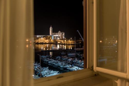 una finestra con vista su un porto turistico di notte di San Paolo Al Convento a Trani