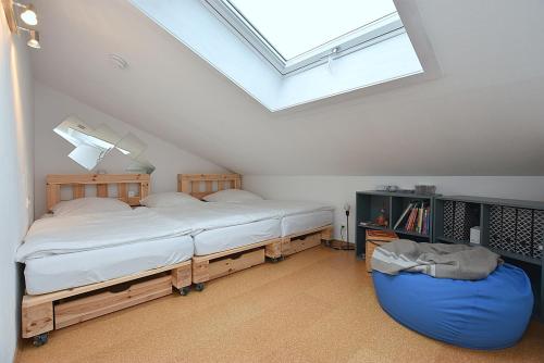 a attic bedroom with two beds and a skylight at FeWo Löwenzahn, Oberstaufen/Wiedemannsdorf in Oberstaufen