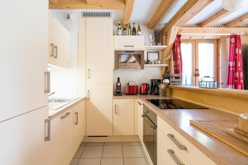 une cuisine avec des armoires blanches et un comptoir dans l'établissement Comme un chalet, appartement à la montagne, à Saint-Gervais-les-Bains