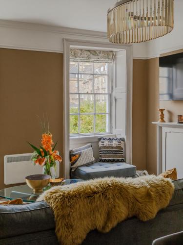a living room with a couch and a window at Impeccable 4-Bed Apartment in Bath in Bath