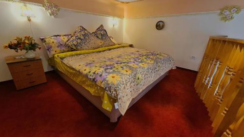 a bedroom with a bed with a floral comforter at River Residence in Timişoara