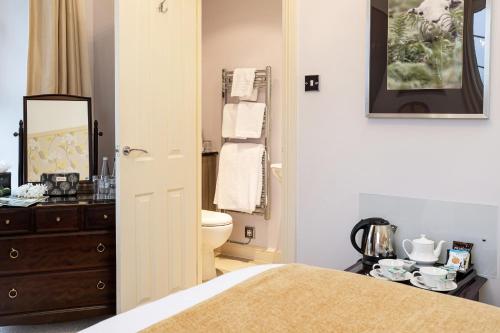 a bathroom with a bed and a sink and a mirror at Ees Wyke Country House in Near Sawrey