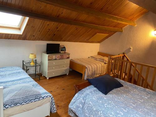 a bedroom with two beds and a wooden ceiling at Maison au calme a l'orée du bois. Accès A13-A14 in Orgeval
