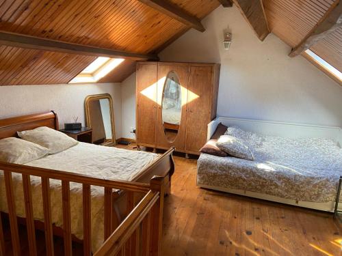 2 letti in una camera con soffitti in legno di Maison au calme a l'orée du bois. Accès A13-A14 a Orgeval