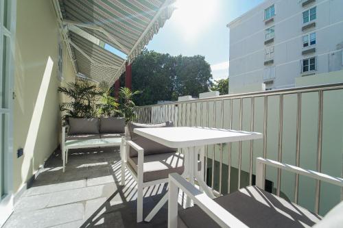 a balcony with a table and chairs and a building at Casa Wilson Inn in San Juan