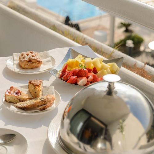 a table with three plates of food and fruit at Mec Paestum Hotel in Paestum