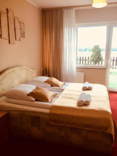 two beds in a bedroom with towels on them at Neptun in Międzychód
