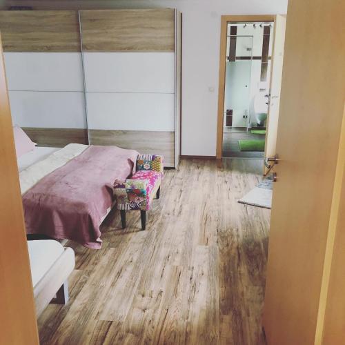 a bedroom with a bed and a chair and a mirror at Landhaus Daum in Schwendau