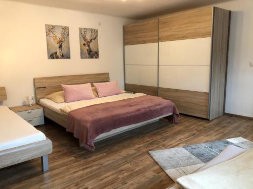 a bedroom with a large bed with pink pillows at Landhaus Daum in Schwendau