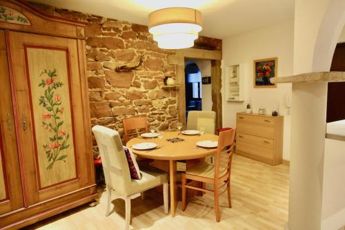 une cuisine et une salle à manger avec une table et des chaises dans l'établissement Appartement chaleureux et cocooning à Barr - Escapade chez Valentine, à Barr