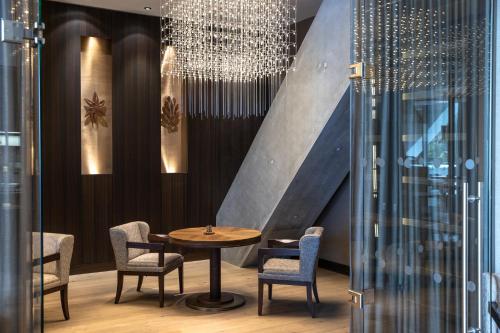 a dining room with a table and chairs and a chandelier at AlpenGold Hotel Davos in Davos