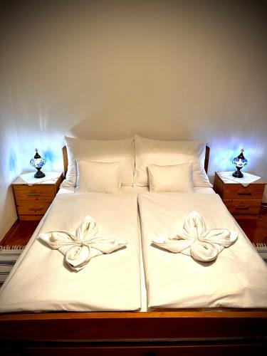1 cama con 2 toallas y 2 lámparas en Green Apartman, en Eger