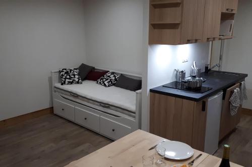 une petite pièce avec un lit et une table dans l'établissement Charming Studio With Balcony, à Mâcot La Plagne