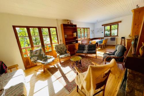 un salon avec des chaises et une table dans l'établissement Family Cottage With Garden In Saint Chaffrey, à Saint-Chaffrey