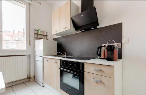 une cuisine avec une cuisinière et un réfrigérateur dans l'établissement Apt 2 Chic, 60m2, 2 Chambres, Centre, à Valenciennes