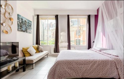 a bedroom with a bed and a couch and windows at Apt 2 Chic, 60m2, 2 Chambres, Centre 1 in Valenciennes